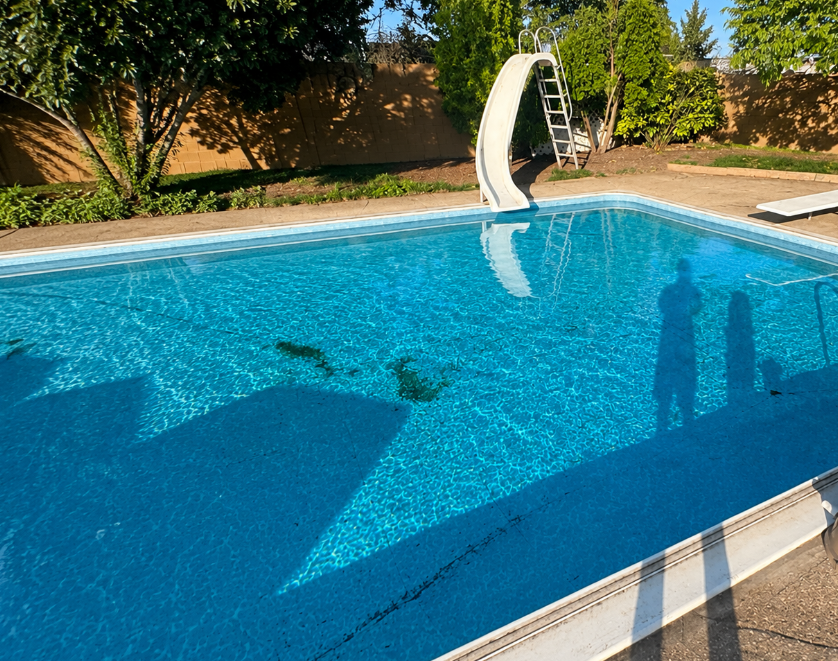 Dirty pool with algae stains and grime along the floor before cleaning